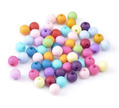 colorful beads are scattered on a white surface for use in crafts or as decoration pieces