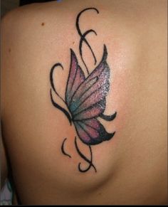 a butterfly tattoo on the back of a woman's shoulder