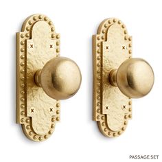 two brass door knobs with rivets on each one and an oval handle