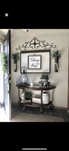 the entry way is decorated with potted plants and a sign that says welcome home