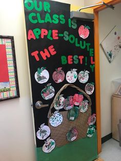 an apple themed classroom door decorated with stickers and magnets that read, our class is apple - solute the best