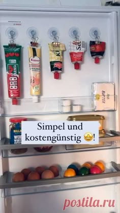 an open refrigerator with some food on the shelves and magnets attached to it's doors