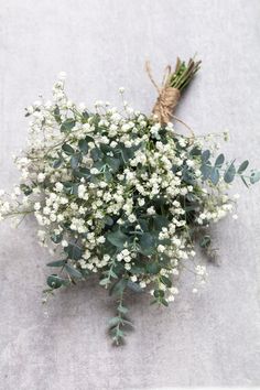 a bunch of white flowers sitting on top of a cement floor next to a string