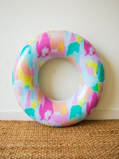 an inflatable donut sits on the floor next to a wall and carpet