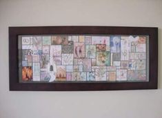 a wooden frame filled with lots of different pictures on the side of a white wall