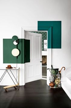 an open door in a room with green and white decor on the walls, along with a small table