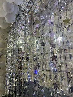 a room filled with lots of white balloons and stars hanging from it's ceiling