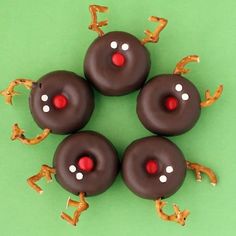 four chocolate donuts with red noses and white dots on them are arranged in the shape of a star