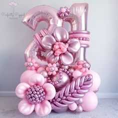 a large balloon shaped like the number twenty five with flowers and balloons attached to it