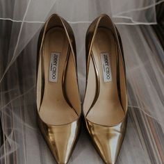 a pair of gold shoes sitting on top of a bed