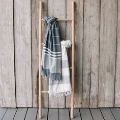 a towel is hanging up on a wooden ladder next to a wall with wood planks