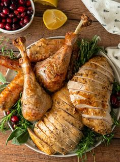 roasted turkey with cranberry sauce and fresh herbs on a white platter surrounded by cherries