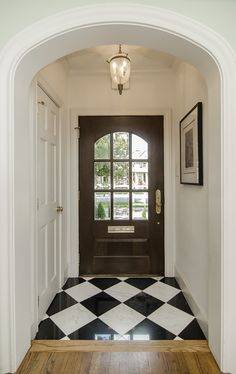 an entry way with a black and white checkered floor