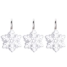 three snowflakes hanging from hooks on a white background