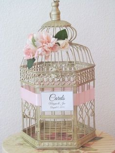 a birdcage with pink flowers on it and a card in the cage that says cards