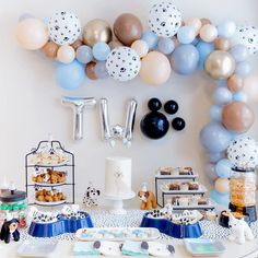 a table topped with lots of balloons and desserts