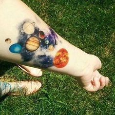 a person's arm with planets painted on it