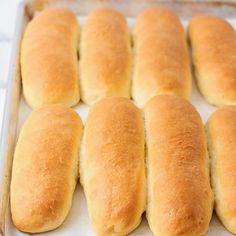 several loaves of bread sitting on top of a baking sheet in a pan, ready to go into the oven