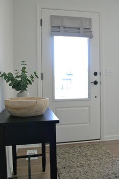 a bowl sitting on top of a table in front of a door with a window