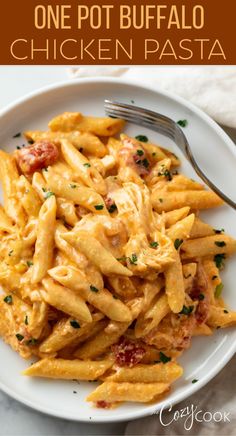 a white plate topped with pasta covered in cheese and tomato sauce next to a fork