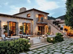 a large house with stone steps leading up to it's front door and patio