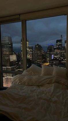 a bedroom with a view of the city at night