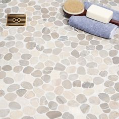 a bathroom with stone flooring and a wooden brush