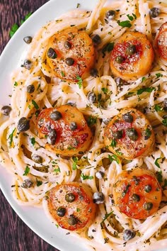 a white plate topped with pasta and olives