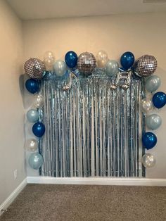 a room filled with balloons and streamers in the shape of disco ballons,