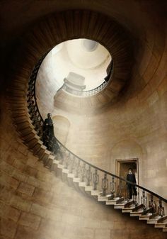 there is a man that is standing at the top of a spiral staircase in a building