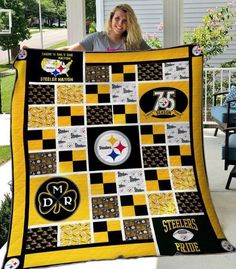 a woman is holding up a quilt that has pittsburgh's logo on it and the number