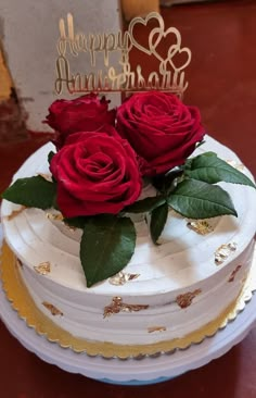 two roses on top of a white cake