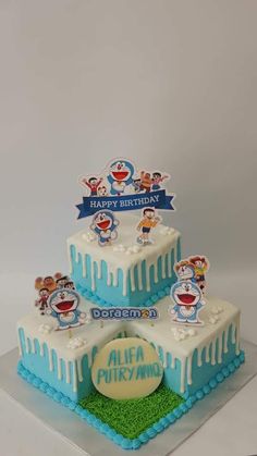 a three tiered birthday cake with frosting on top