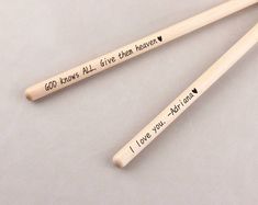 three wooden chopsticks with words written on them, one says god knows all give peace and the other says i love you