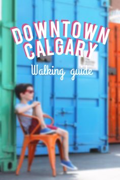 a woman sitting on top of a chair next to blue shipping containers and the words downtown calgary