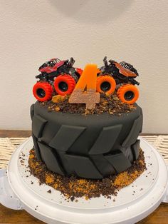 a birthday cake with monster trucks on top