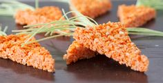 several pieces of food are arranged on a table with grass sprouts sticking out of them