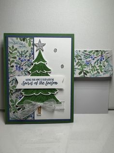 a card with a christmas tree on the front and bottom, which has a ribbon attached to it