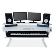 a computer desk with two monitors, keyboard and speakers on top of it in front of a white background