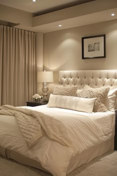 a large bed sitting in a bedroom next to two lamps on either side of it