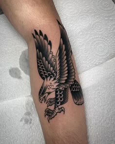 a black and white eagle tattoo on the arm