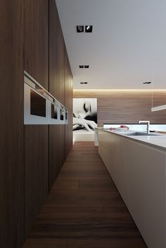 an empty kitchen with white counter tops and wooden cabinets on either side of the room