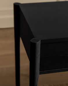 a black table sitting on top of a hard wood floor