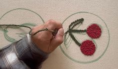 someone is crocheting three flowers on a piece of fabric