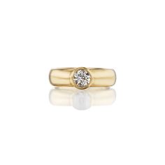 a yellow gold ring with a single diamond in the center, on a white background