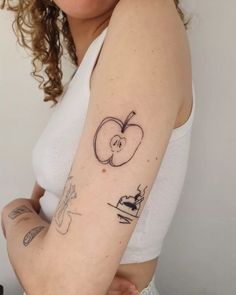 a woman with a tattoo on her arm has an apple and knife in the shape of a heart