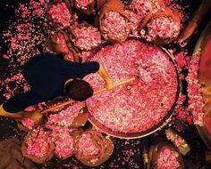 a man standing in front of a large amount of pink sprinkles