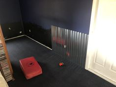 an empty room with blue walls and black carpet