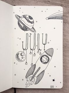 an open notebook with space drawings on it