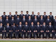 a large group of men in suits and ties posing for a team photo with each other